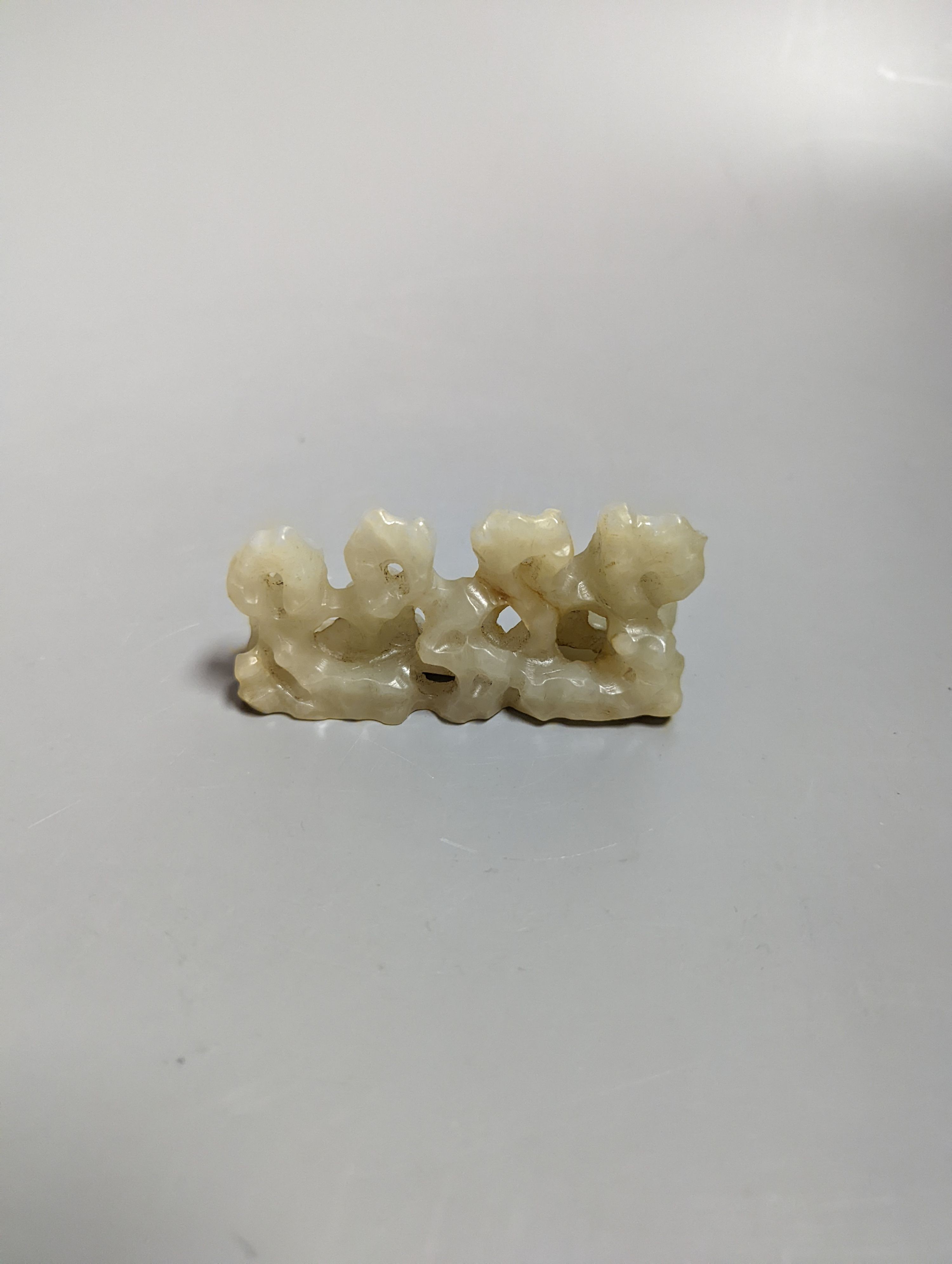 A Chinese celadon jade brush rest, 8cms wide